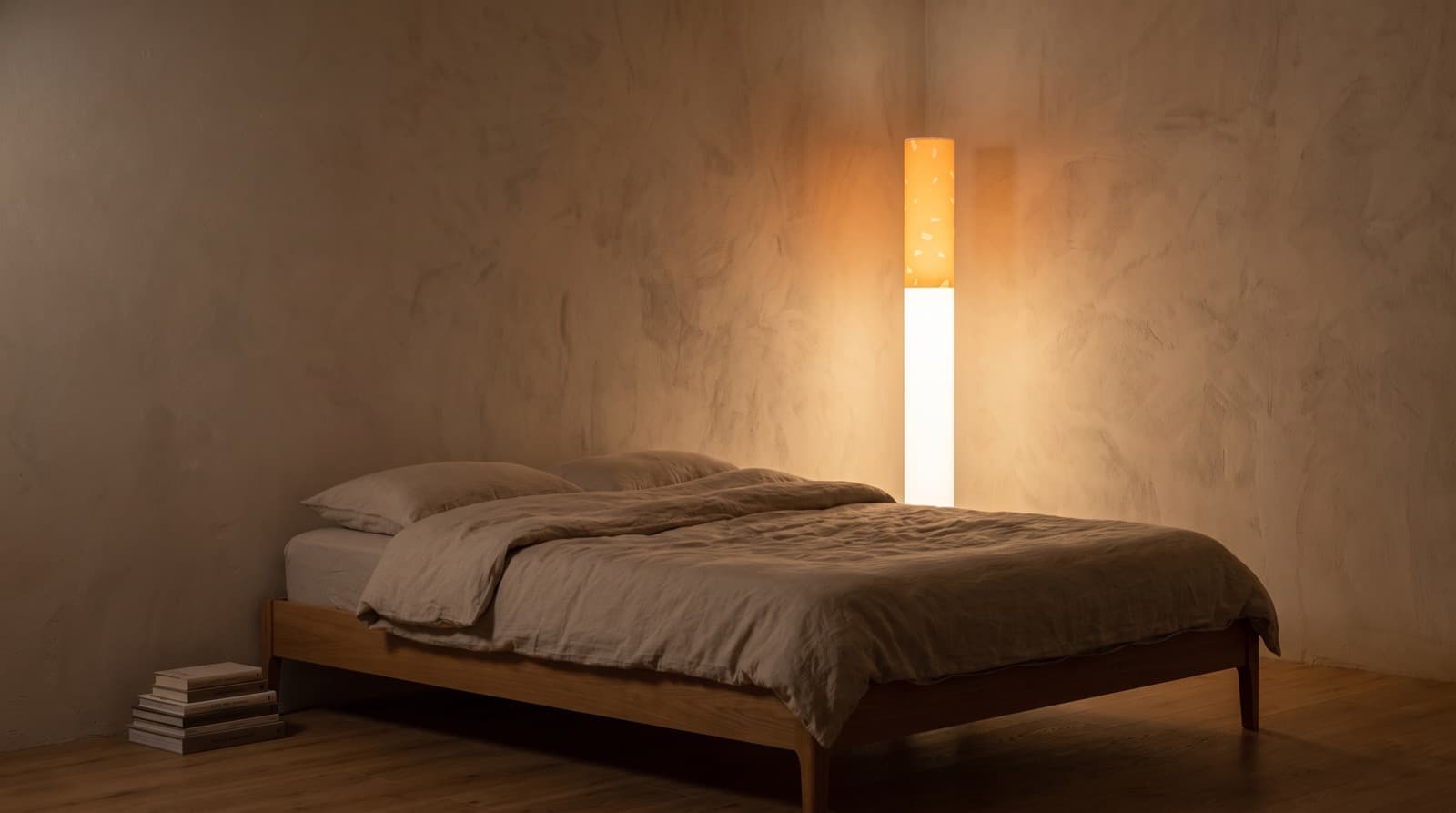 The lamp as the only light in a warm minimal bedroom with linen bedding